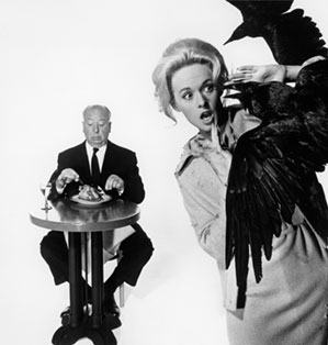 Tippi Hedren is attacked by ravens while Alfred Hitchcock casually enjoys a roasted chicken.